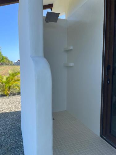 a white wall next to a door with a window at Farmer's house in El Quije