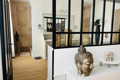 een kamer met een vaas op een witte plank bij Hôtel Particulier - 5 minutes de Reims in Reims