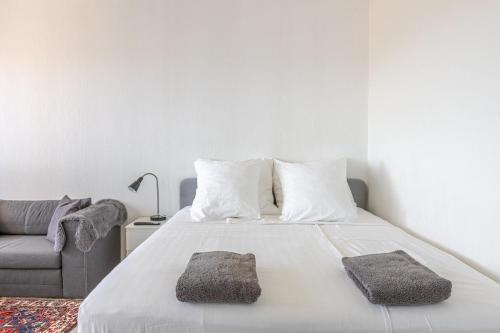 a bedroom with a bed with two pillows and a couch at Traumhaftes Studio in Top Lage! in Saint-Louis