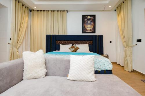 a bedroom with a bed and a couch with pillows at Studio Room by Elegushi beach resort in Mama