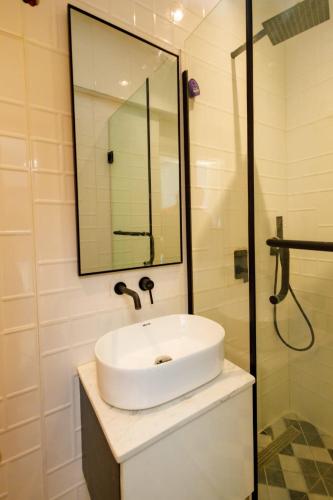 a bathroom with a white sink and a mirror at Studio Room by Elegushi beach resort in Mama