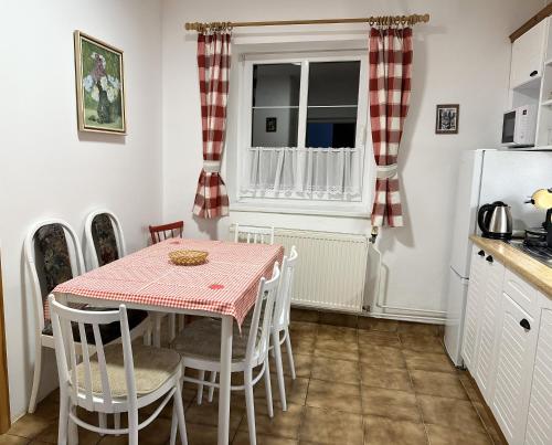 una cucina con tavolo, sedie e frigorifero di Chalupa u Valiky a Podtureň