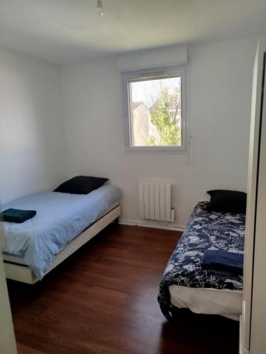a bedroom with two beds and a window at Bel appartement 3 pièces climatisation in Saint-Alban