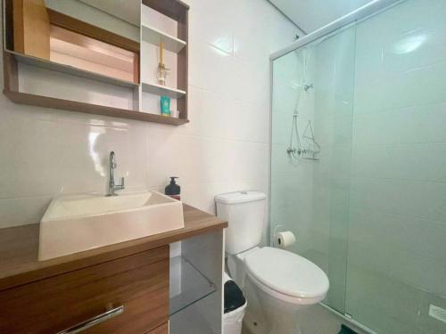 een badkamer met een toilet, een wastafel en een douche bij Apartamento no centro de Torres Rs in Torres