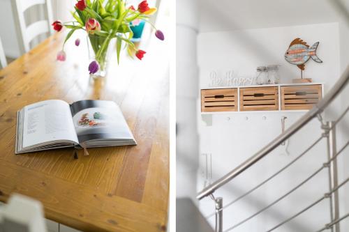ein Buch auf einem Tisch mit einer Blumenvase in der Unterkunft Strandperle Ney in Norderney