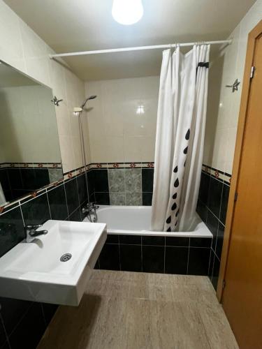 a bathroom with a sink and a tub and a shower at Cala Llobeta in Calafat