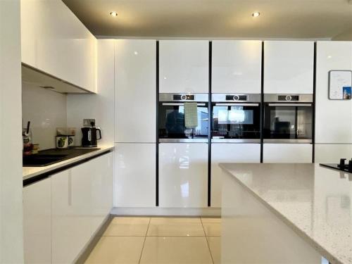 a white kitchen with white cabinets and a counter at Cozy home in Birmingham