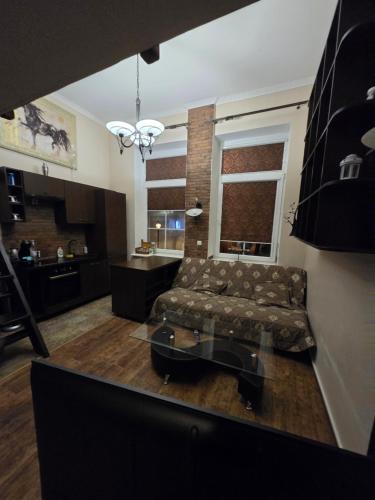een woonkamer met een bank en een tafel bij Old Wine House in Klaipėda
