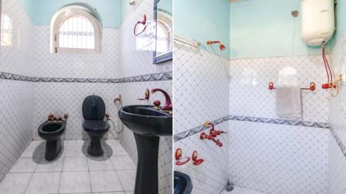 een badkamer met een zwart toilet en een wastafel bij Malti Guest House in Kullu Manali