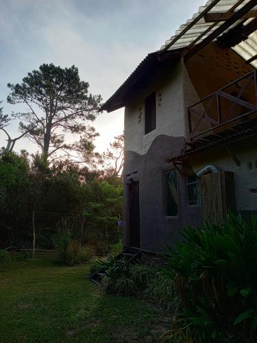 een oud huis met een boom op de achtergrond bij Raices del Mar in La Pedrera