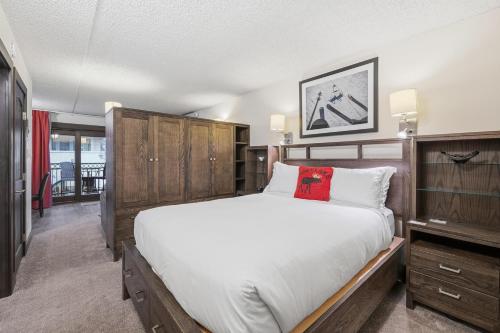 a bedroom with a large bed and wooden cabinets at Lift House Lodge, Close to Gondola, Premium Studio Condo in Vail