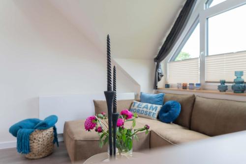 诺德奈Neywatt 1的客厅配有沙发,花瓶里鲜花