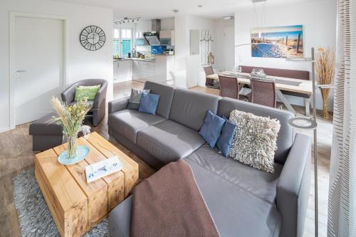 een woonkamer met een grijze bank en een tafel bij Utspann in Norderney