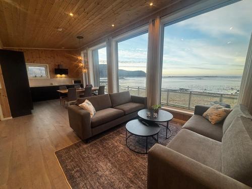 a living room with a couch and a large window at Unik og moderne hytte med utsikt mot havet 38 Otterlei Resort in Haram