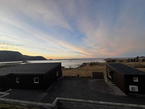 a view of the ocean from the roofs of two houses at Unik og moderne hytte med utsikt mot havet 38 Otterlei Resort in Haram