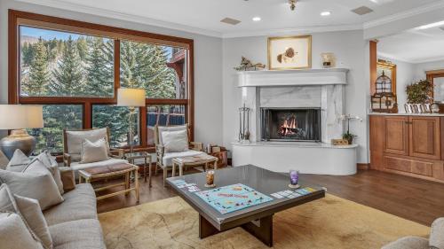 a living room with a fireplace and a table at Chalet Premio in Beaver Creek