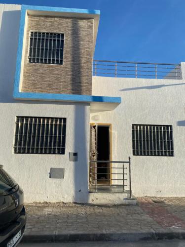 ein weißes Gebäude mit einer Tür und einem Tor in der Unterkunft Mini villa trougout in Al Hoceïma