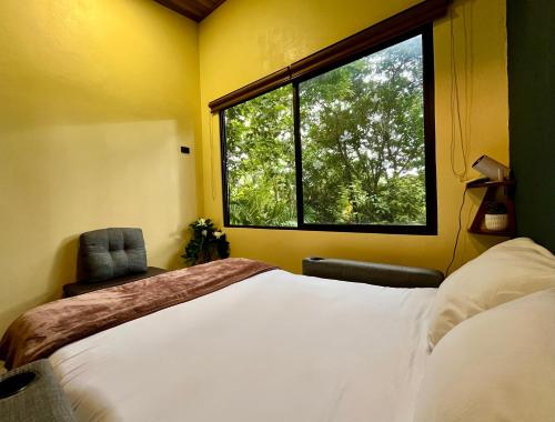 een slaapkamer met een groot bed en een raam bij Jungle House with Private Jacuzzi in Uvita