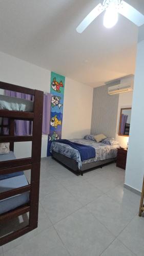 ein Schlafzimmer mit einem Bett und einem Etagenbett in der Unterkunft Aurora Peruíbe Hotel in Peruíbe