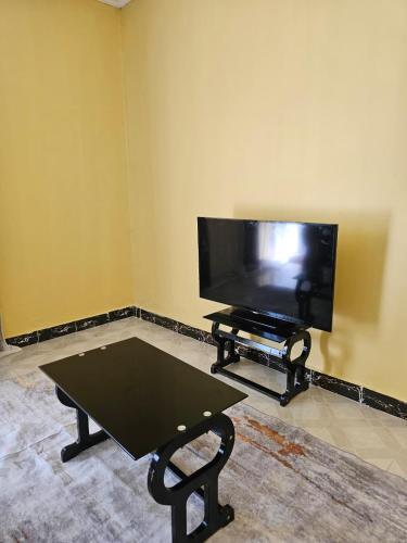 a living room with a flat screen tv and a coffee table at ZuriStay in Nakuru