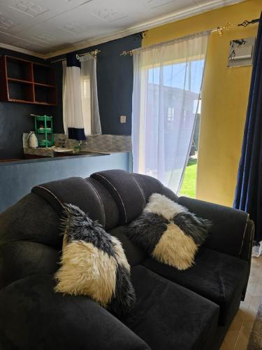 a couch with pillows on it in a living room at ZuriStay in Nakuru