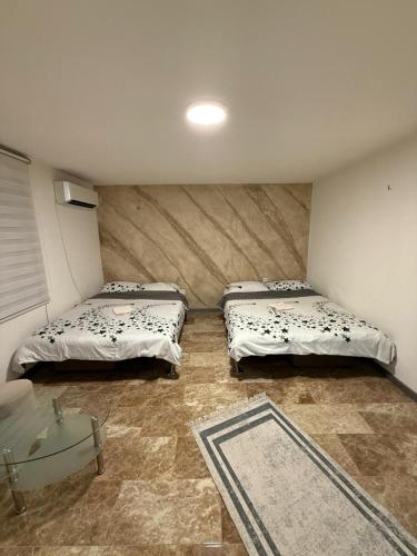 a room with two beds and a glass table at Stan na dan Berane in Berane