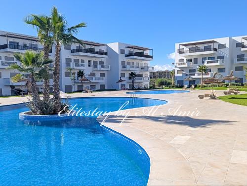 a swimming pool in front of a building at Elite'Stay by Al Amir in Cabo Negro