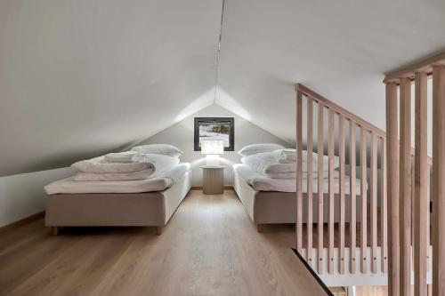 two twin beds in a room with a staircase at Unique Tromsø mini-house! in Tromsø