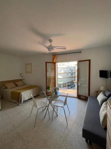 a living room with a bed and a table and chairs at Apartamentos El Sol in Tossa de Mar