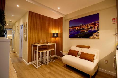 a living room with a white couch and a table at Feel Porto in Bolhão "Metro at your doorstep" in Porto