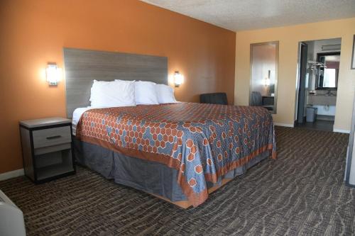een hotelkamer met een groot bed met oranje muren bij Royal Inn in Port Arthur