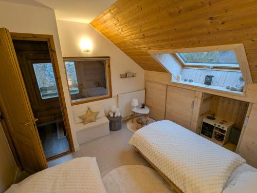 una piccola stanza con due letti e una finestra di Le Ptit Beccon a Cruseilles