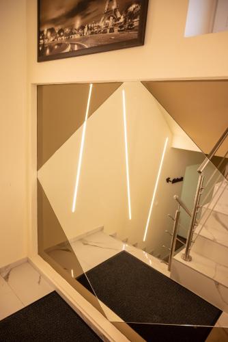 a room with a glass wall with a stair case at Centrum Apartman in Nagykálló