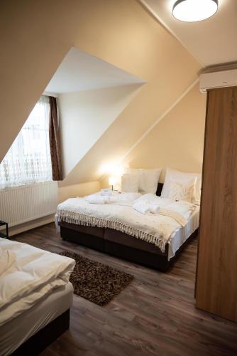 a bedroom with two beds in a attic at Centrum Apartman in Nagykálló