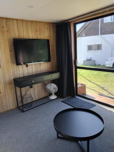 a living room with a flat screen tv and a table at TuiStay in Cromwell