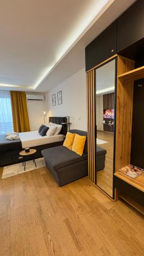 a bedroom with a bed and a couch and a mirror at Skyline Panorama in Vrnjačka Banja