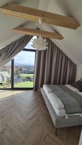 a bedroom with a bed and a large window at BeskidView Meszna 1 in Meszna