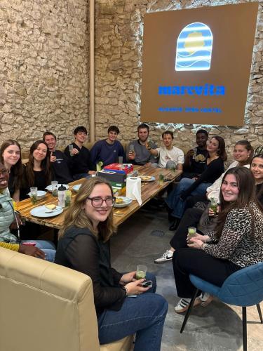 a group of people sitting at tables in a room at Marevita Hostel in Alicante