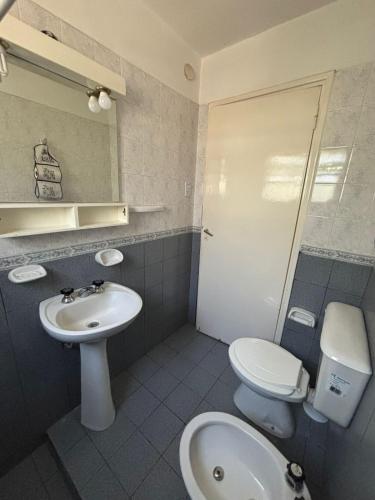 a bathroom with a sink and a toilet and a mirror at Paraíso in Mina Clavero