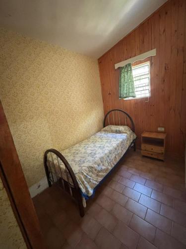 a small bedroom with a bed and a window at Paraíso in Mina Clavero