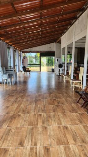 een grote kamer met een houten vloer en stoelen bij Sítio com Espaço para Eventos in São Francisco do Sul