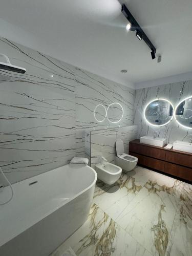 a bathroom with a tub and a toilet and a sink at KNIGHT RESORT Villa & Rooms in Voluntari