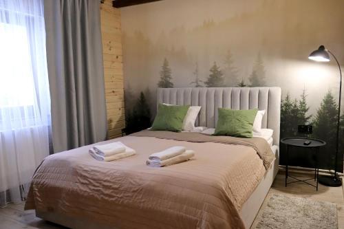 een slaapkamer met een bed met handdoeken erop bij Садиба "Hutsulyana" in Dobrovelychkivka