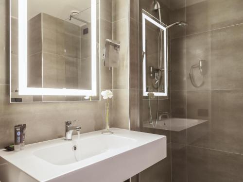 a bathroom with a sink and a mirror and a shower at Novotel Brescia Due in Brescia