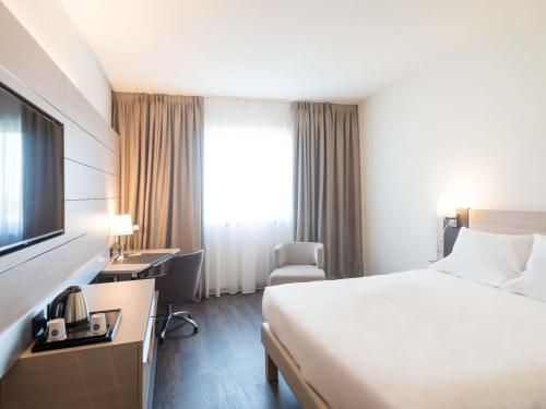 a hotel room with a bed and a television at Novotel Brescia Due in Brescia