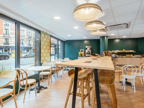 ein Konferenzraum mit Tischen und Stühlen und Fenstern in der Unterkunft Aparthotel Adagio Paris Malakoff Chatillon in Malakoff