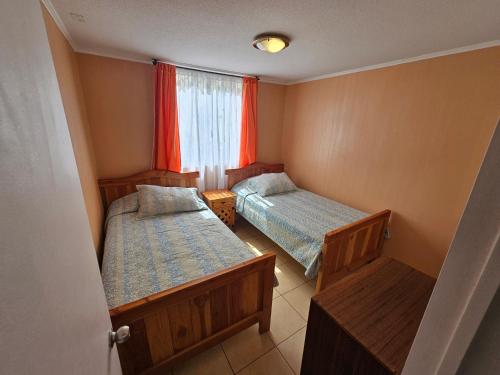 a small room with two beds and a window at Arriendo Departamento Diario en Copiapo in Copiapó