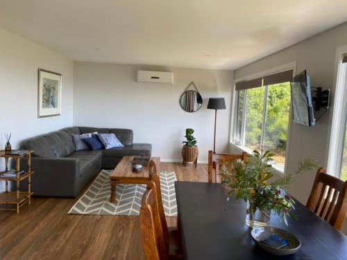 a living room with a couch and a table at Penguin Seaside Farm in Penguin
