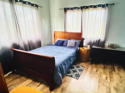 a bedroom with a bed and a desk and curtains at Mayaro getaway in Saint Margaret