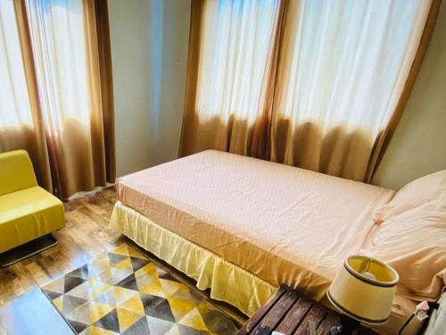 a bedroom with a bed and a yellow chair at Mayaro getaway in Saint Margaret